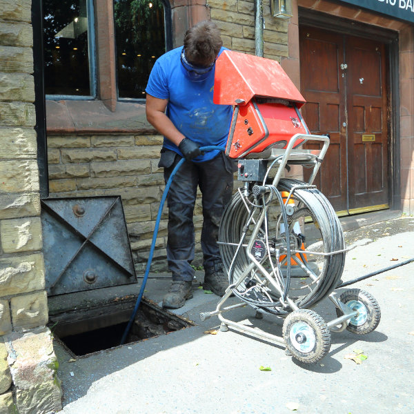 A drain jetting system being used to unblock a drain