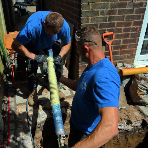 Two drain experts working on a drain lining project
