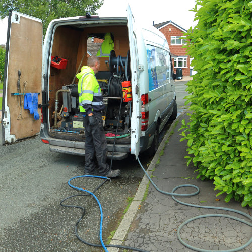 One of our drainage specialists accessing equipment in the back of a drain van